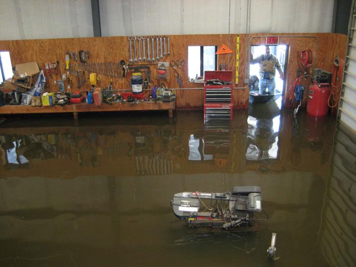 water damage inside a workshop with dry tools hanging from wall