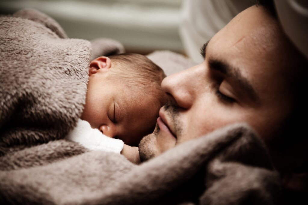 baby sleeping on man's chest