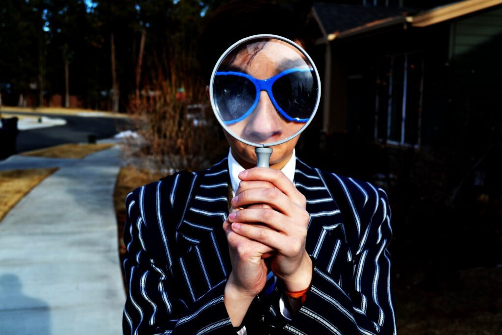 man looking through magnifying glass