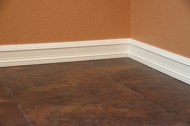 hardwood floor with white baseboards