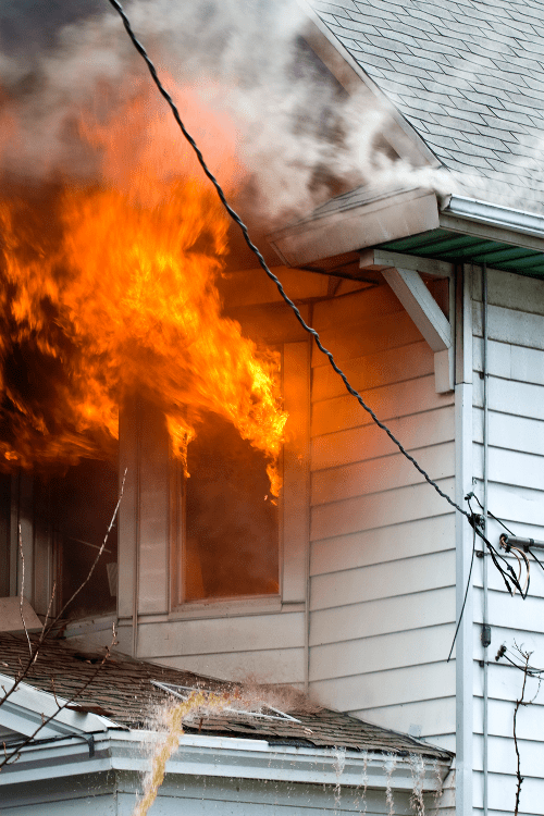 house with white siding and flames coming from window